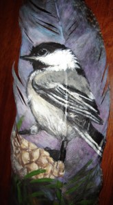Chickadee on pine cone on feather